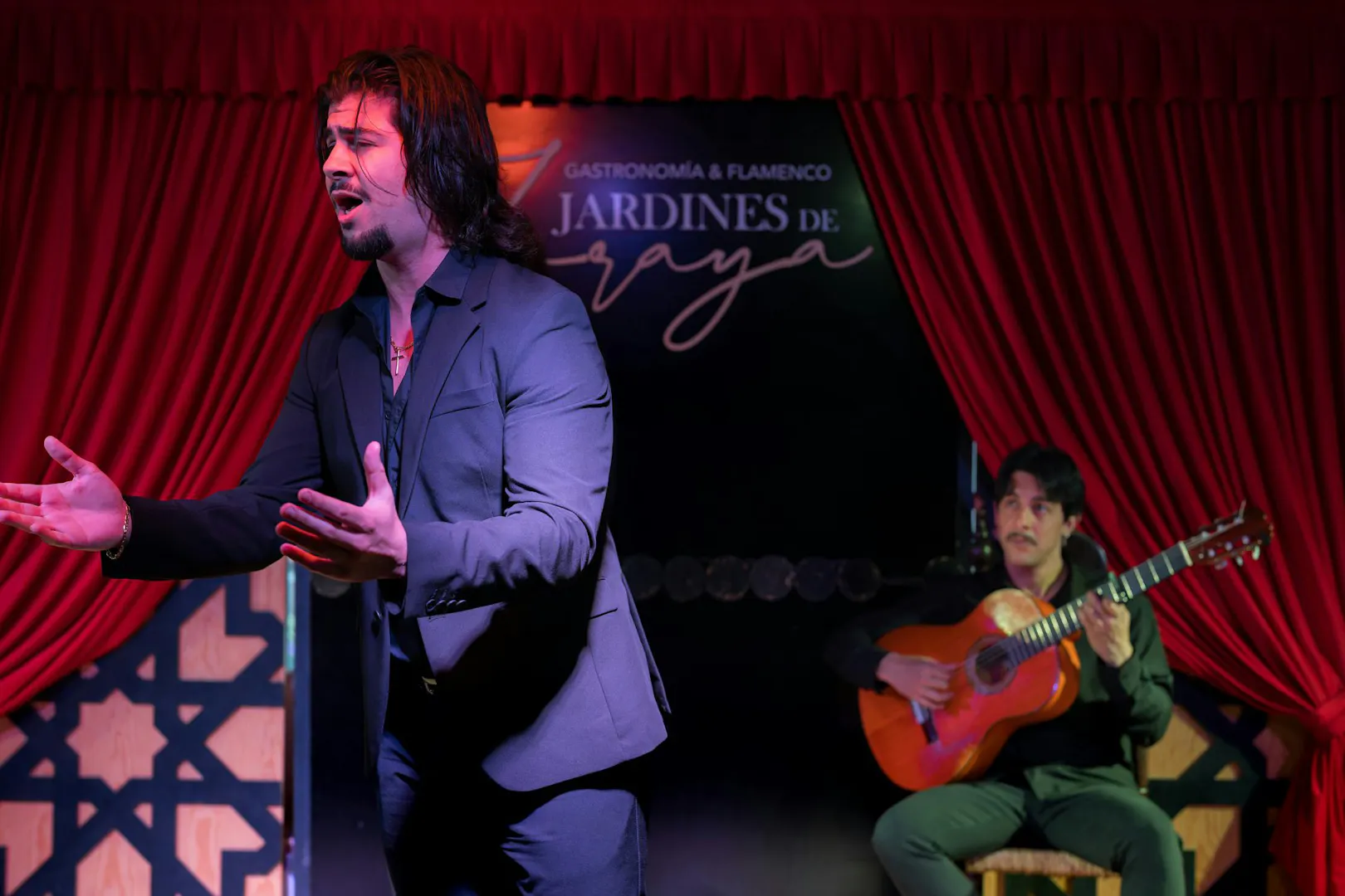 Flamenco singer performing with guitarist at Tablao Jardines de Zoraya.