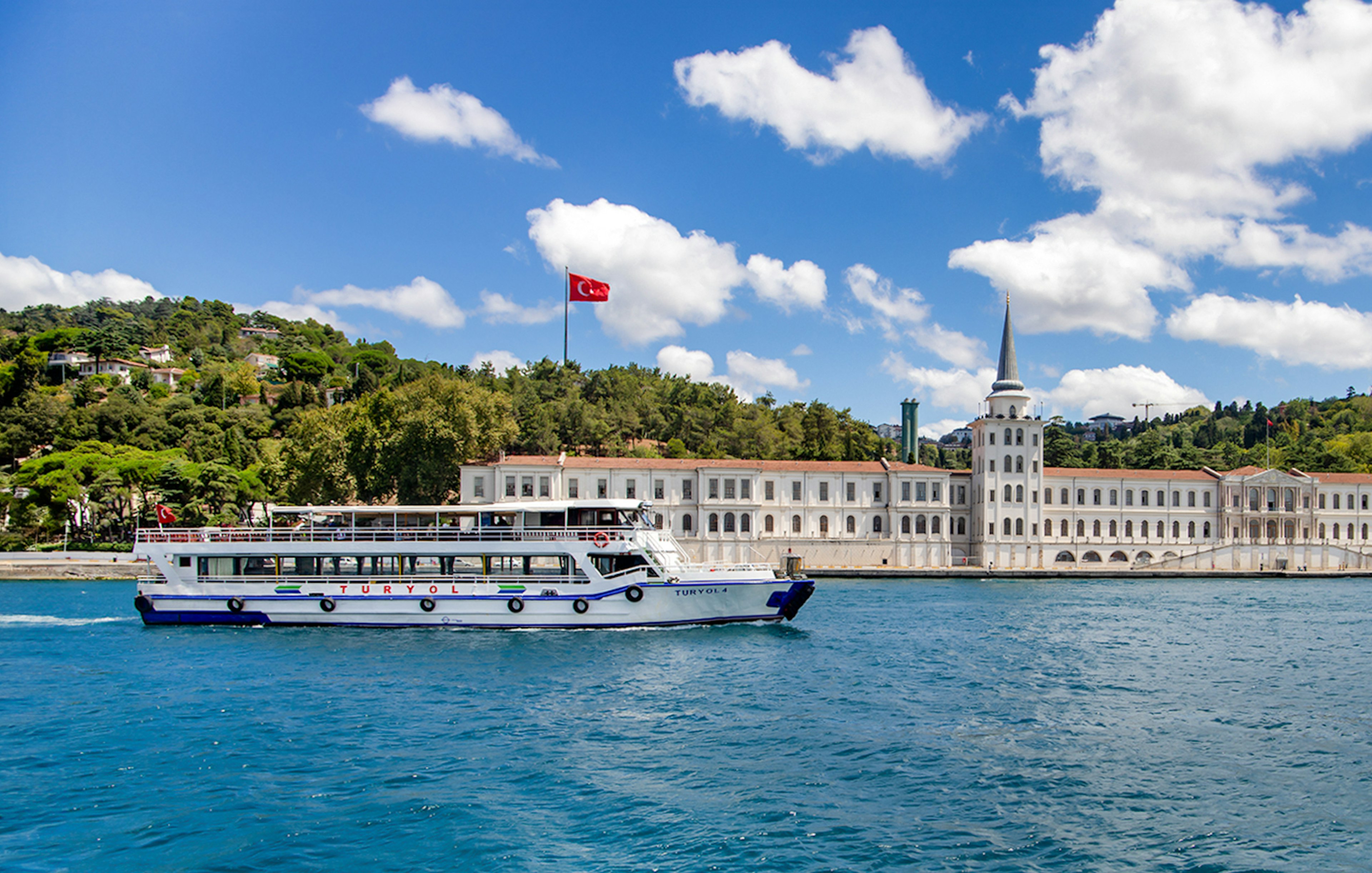 Tour boat on the Bosphorus with Kuleli Military High School in the background, Istanbul.