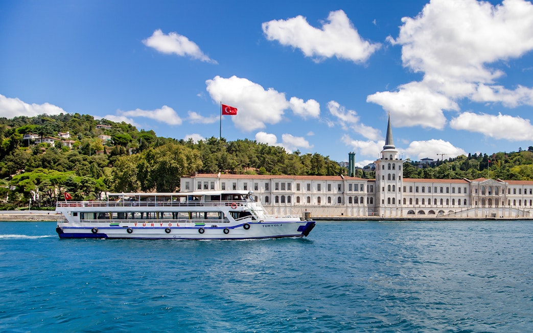 Tour boat on the Bosphorus with Kuleli Military High School in the background, Istanbul.