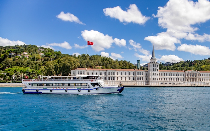 Tour boat on the Bosphorus with Kuleli Military High School in the background, Istanbul.