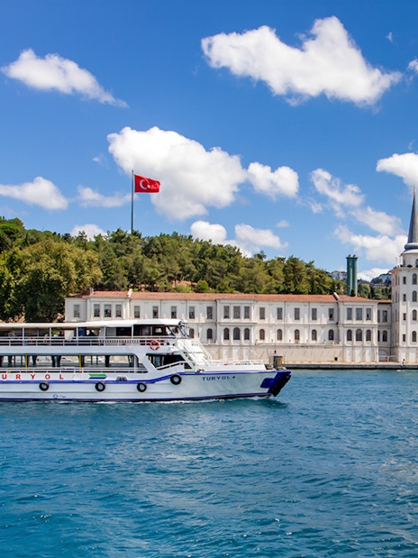 Tour boat on the Bosphorus with Kuleli Military High School in the background, Istanbul.