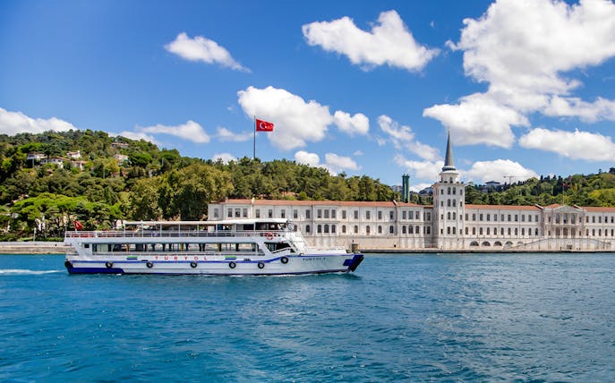 Tour boat on the Bosphorus with Kuleli Military High School in the background, Istanbul.