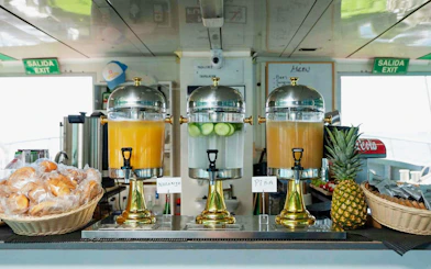 Juice dispensers and breakfast pastries on Ibiza to Formentera cruise.