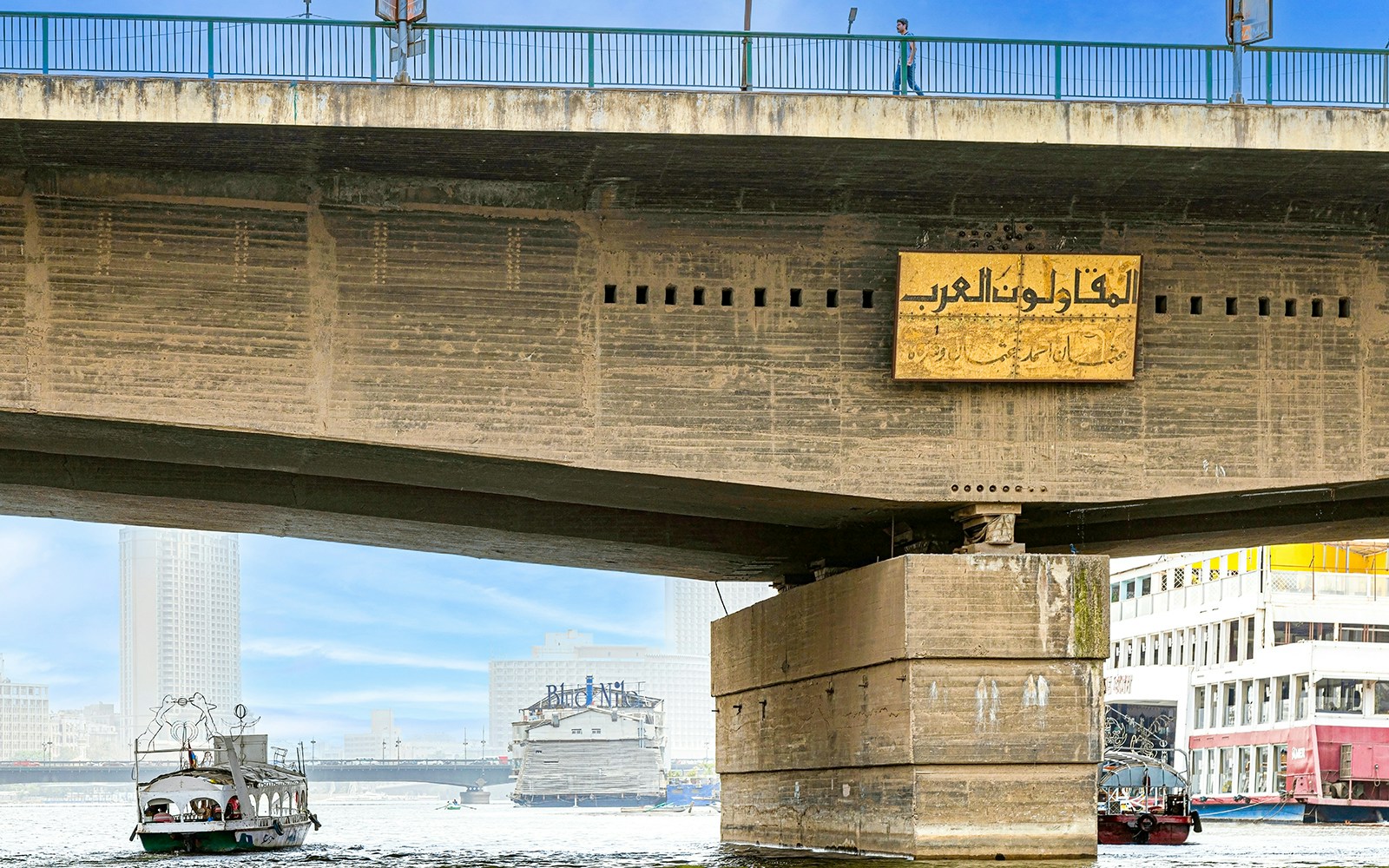 6th October Bridge over the Nile River in Cairo, Egypt, with boats passing underneath.