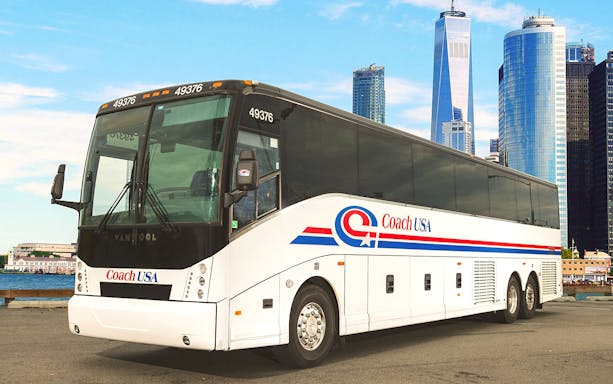 Coach USA bus parked with city skyline in background, route from Chicago O'Hare to Milwaukee.