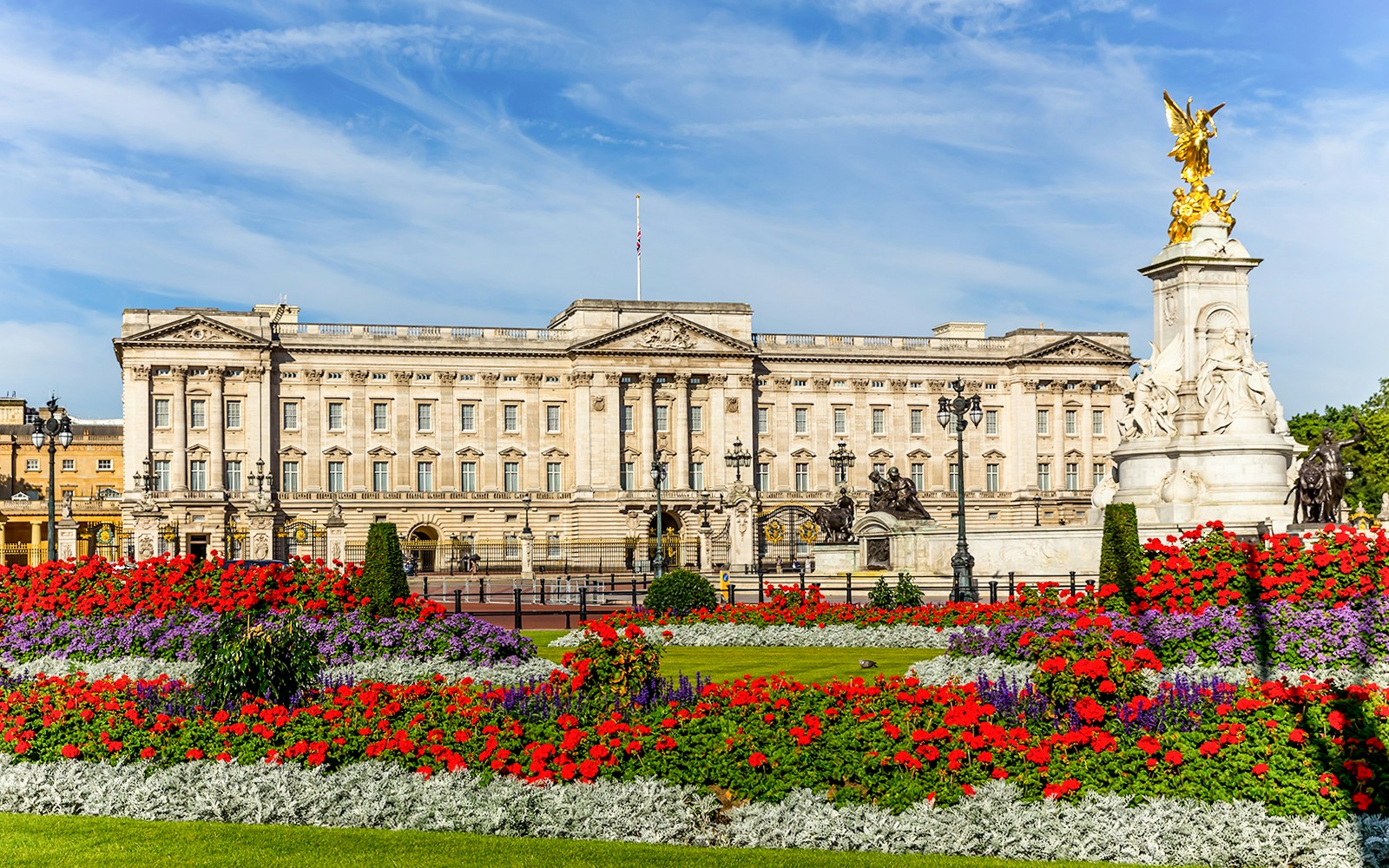 Buckingham Palace with vibrant flower gardens and Victoria Memorial in London.