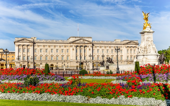 Buckingham Palace with vibrant flower gardens and Victoria Memorial in London.