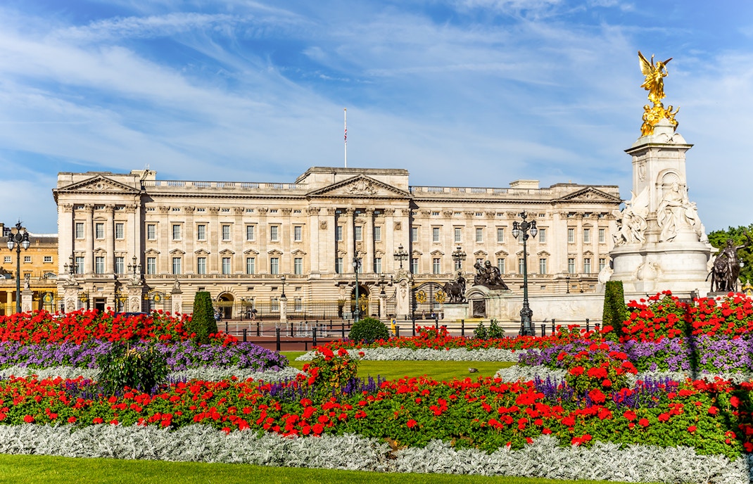 Buckingham Palace with vibrant flower gardens and Victoria Memorial in London.