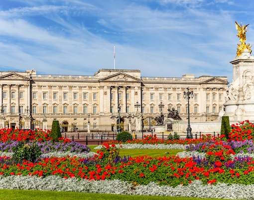 Buckingham Palace with vibrant flower gardens and Victoria Memorial in London.