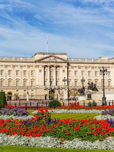 Buckingham Palace with vibrant flower gardens and Victoria Memorial in London.
