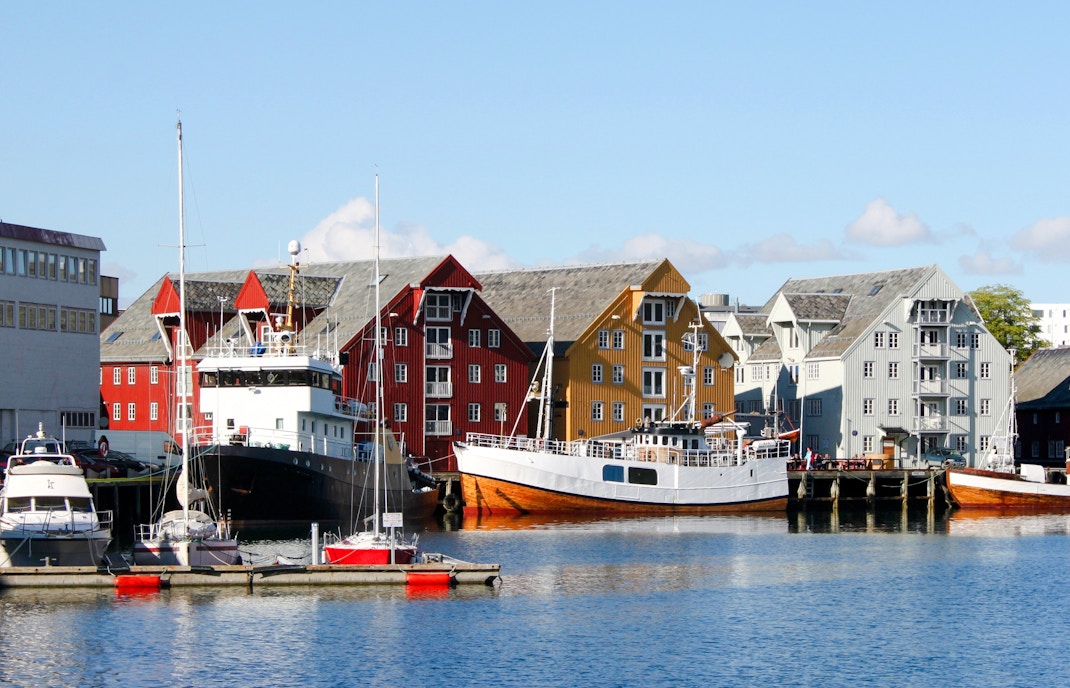 Colorful wooden buildings and boats in Tromso City Center harbor.