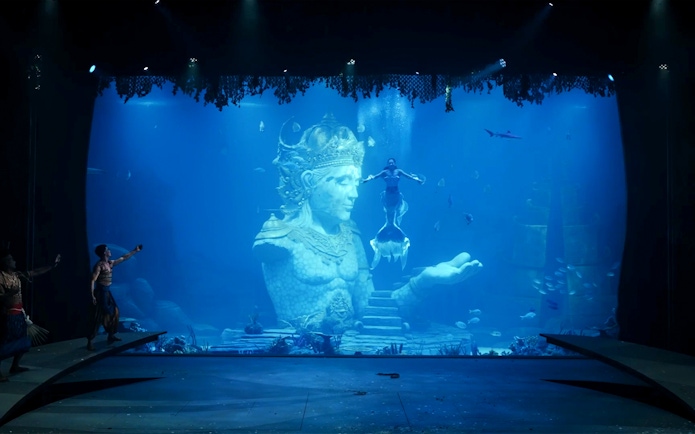Underwater performance with mermaid near Varuna statue in theatrical dining experience.