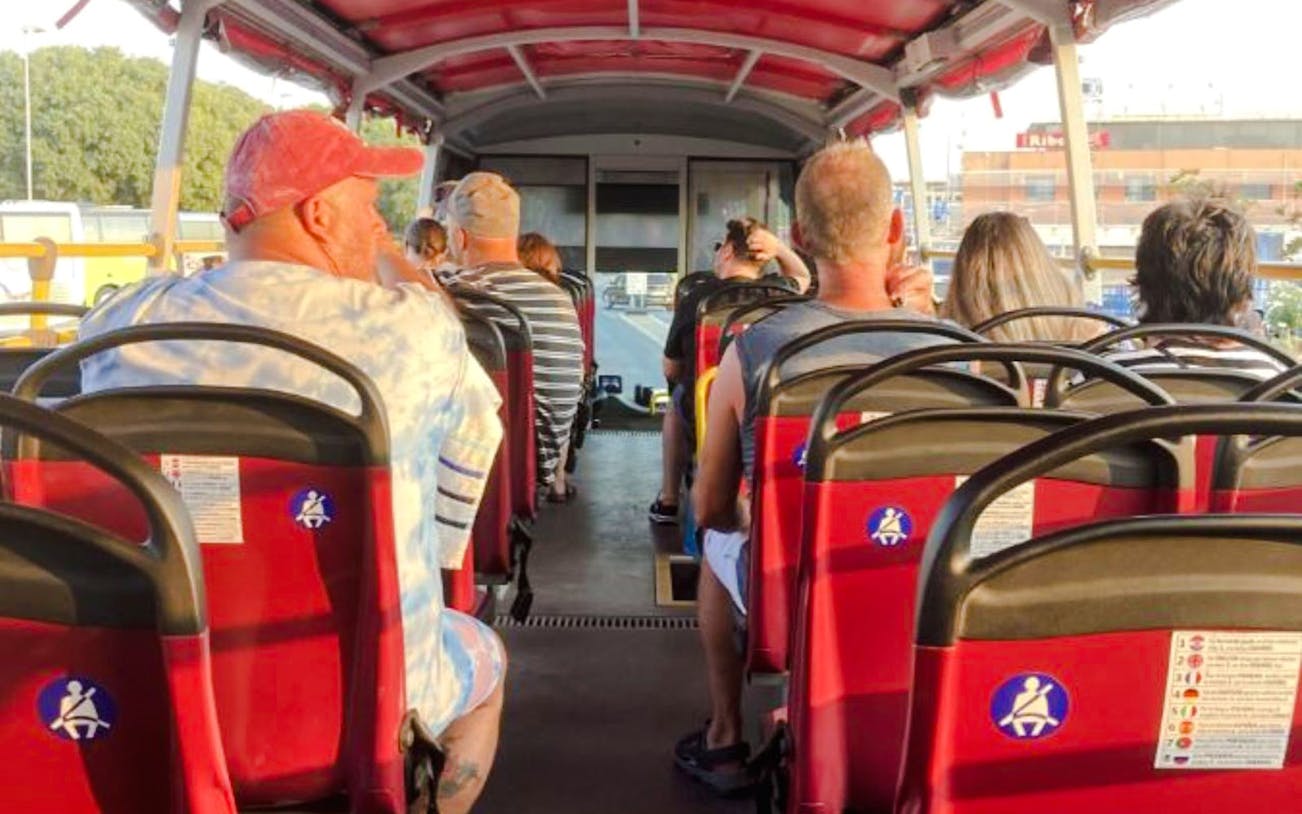 Tourists seated on an open-top bus during Klis Fortress sunset tour.