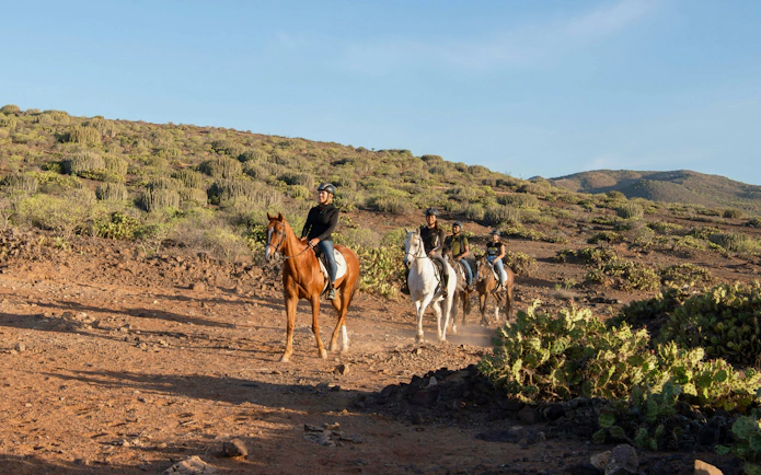 Horseback riders on a volcanic trail in Gran Canaria.