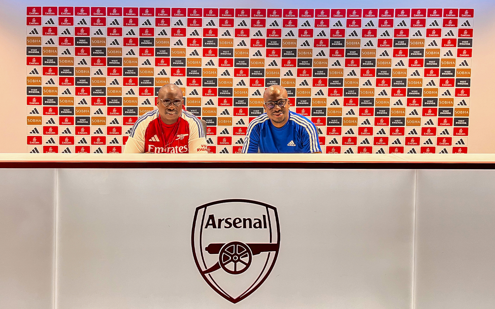 Arsenal FC Emirates Stadium press room with two people seated at the desk.