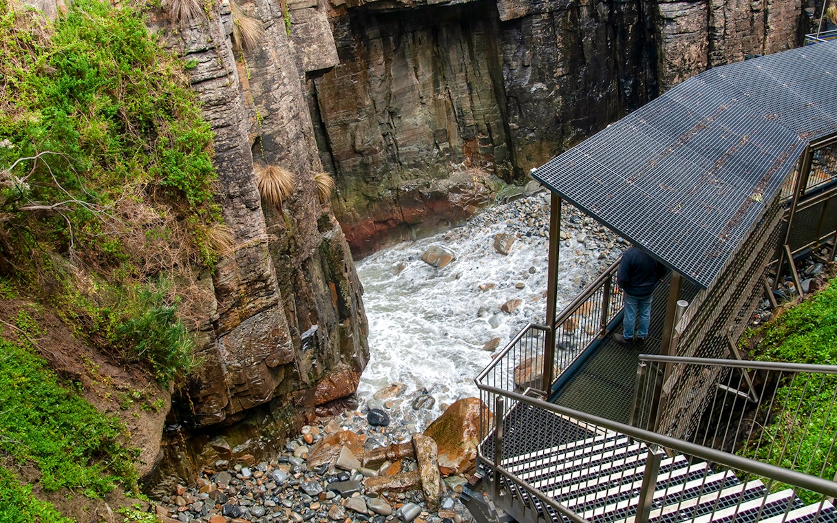 Cliffside walkway overlooking rocky stream at Port Arthur, Tasmania.