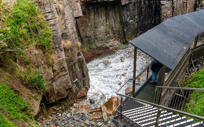 Cliffside walkway overlooking rocky stream at Port Arthur, Tasmania.