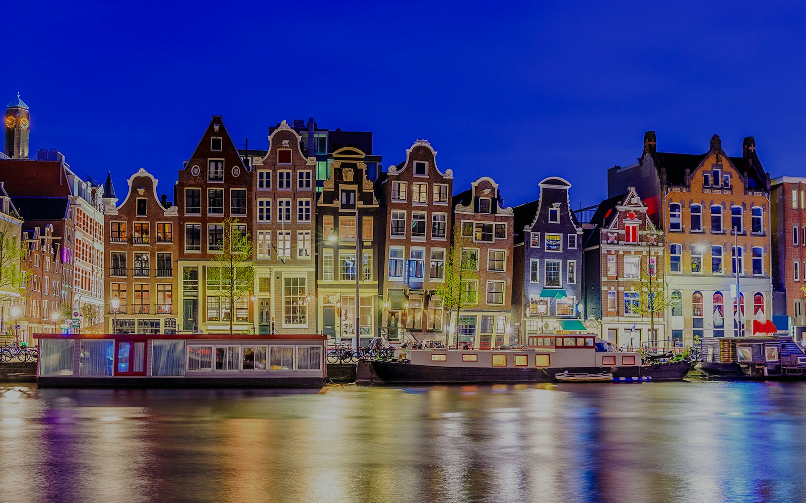 Colorful canal houses along the water in Amsterdam, Netherlands.