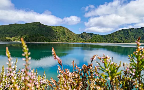 Lagoa do Fogo with lush green hills and clear blue water, Azores.