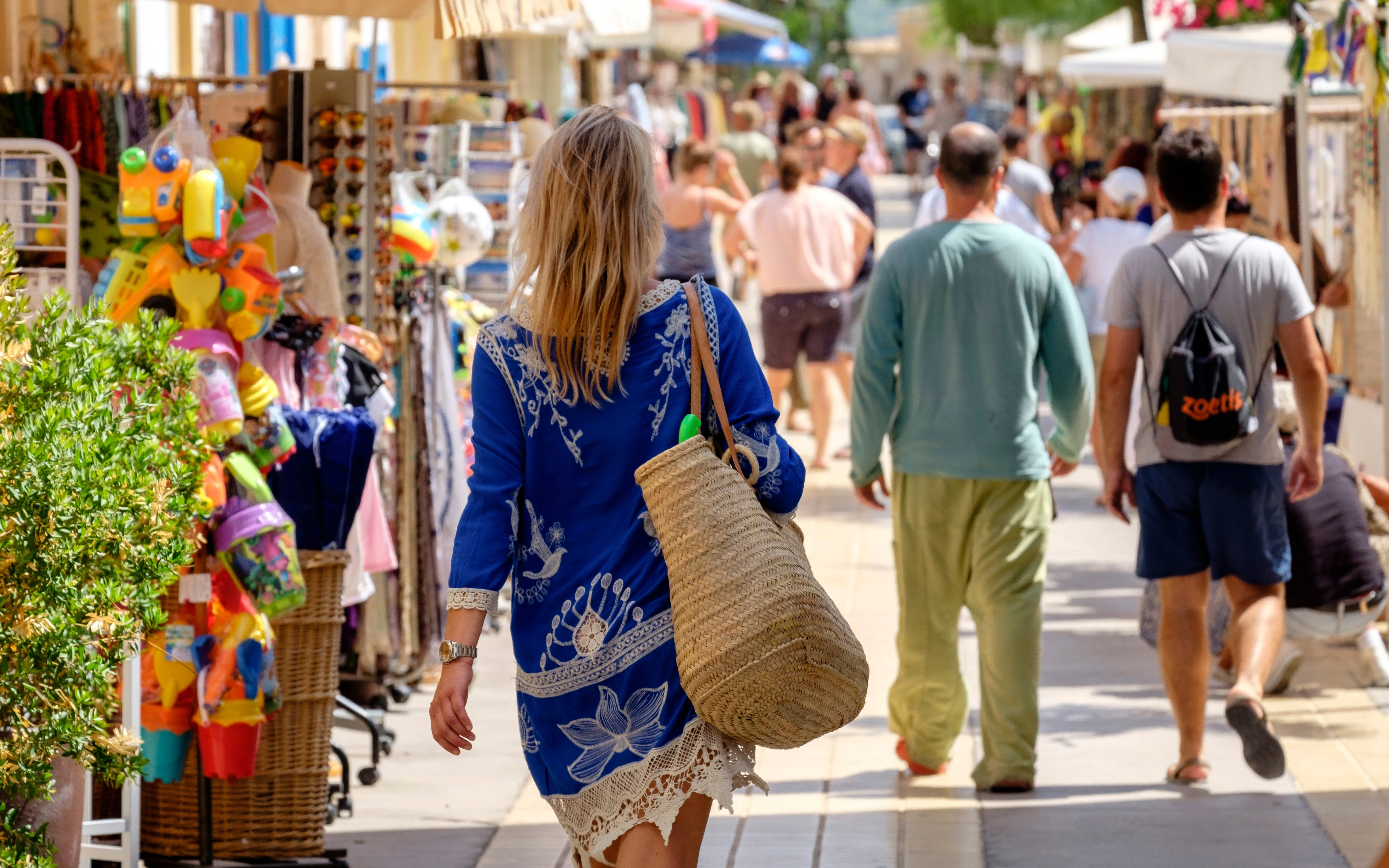 Shoppers walking through a vibrant market street in Sant Francesc, Formentera, Balearic Islands, Spain.