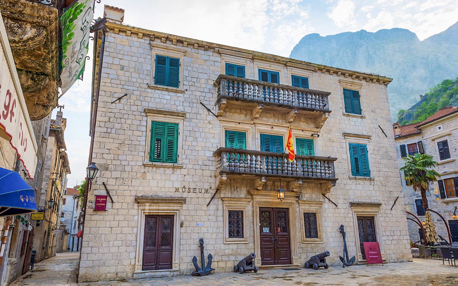 Maritime museum building with flag and cannons in Kotor, Montenegro.