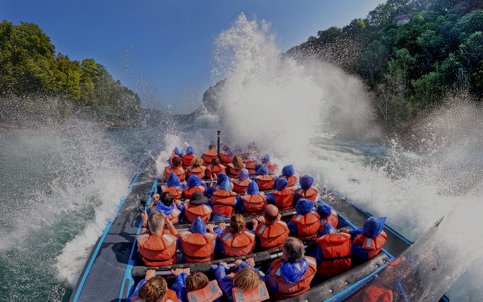 Guests on Whirlpool Jet Boat Tour in Niagara Gorge, Canada, experiencing water splashes.