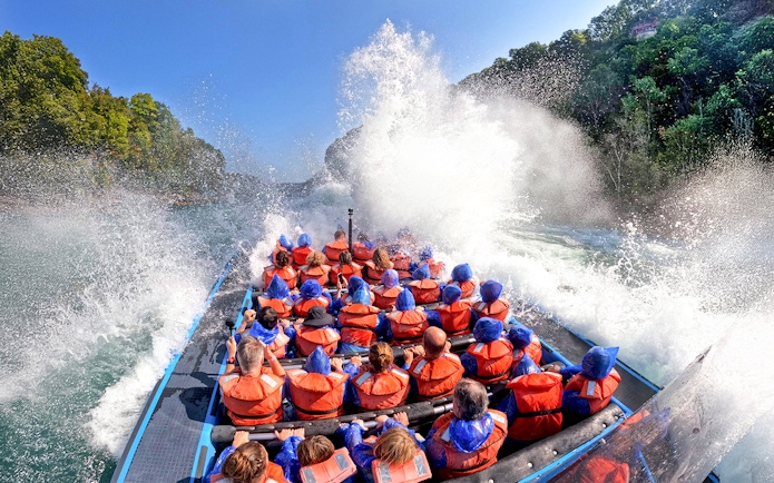 Guests on Whirlpool Jet Boat Tour in Niagara Gorge, Canada, experiencing water splashes.