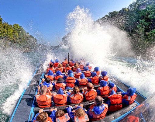 Guests on Whirlpool Jet Boat Tour in Niagara Gorge, Canada, experiencing water splashes.