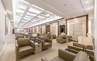 Spacious lounge area at Shanghai Pudong International Airport Terminal 1 with seating and lamps.