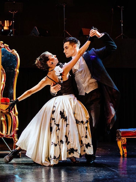 Dancers performing at Tango Porteño Show in front of ornate mirror.