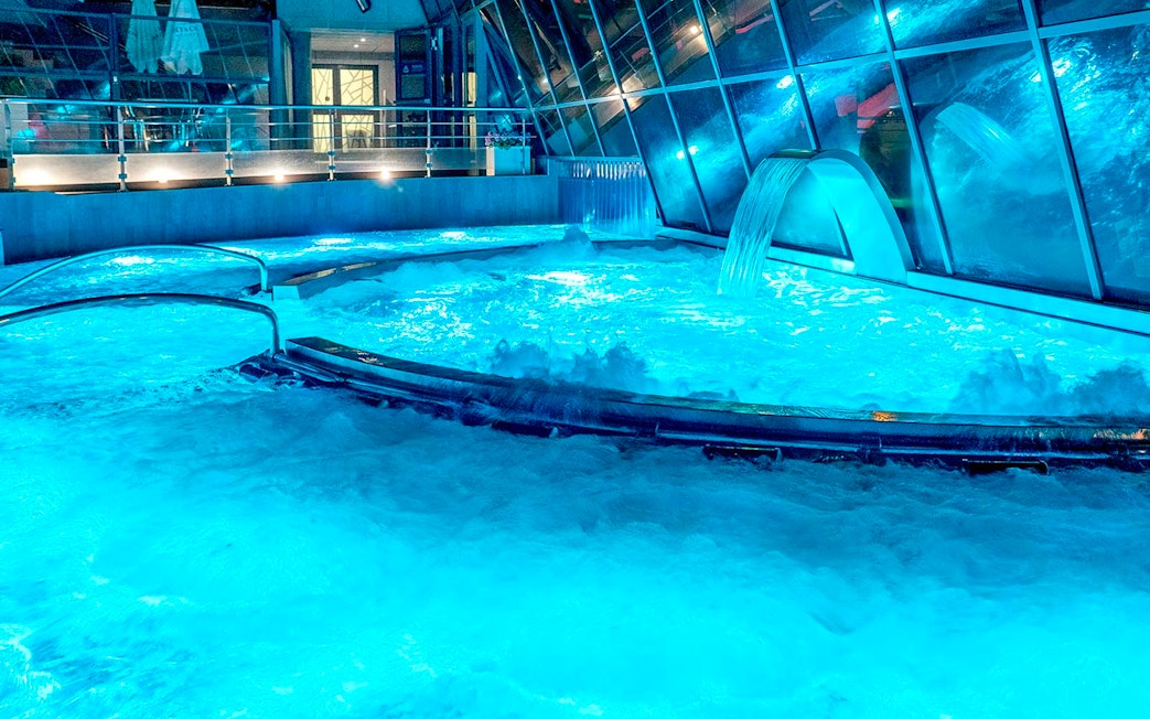 Caldea spa thermal pools with cascading water and mountain views in Andorra.