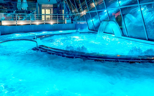 Caldea spa thermal pools with cascading water and mountain views in Andorra.