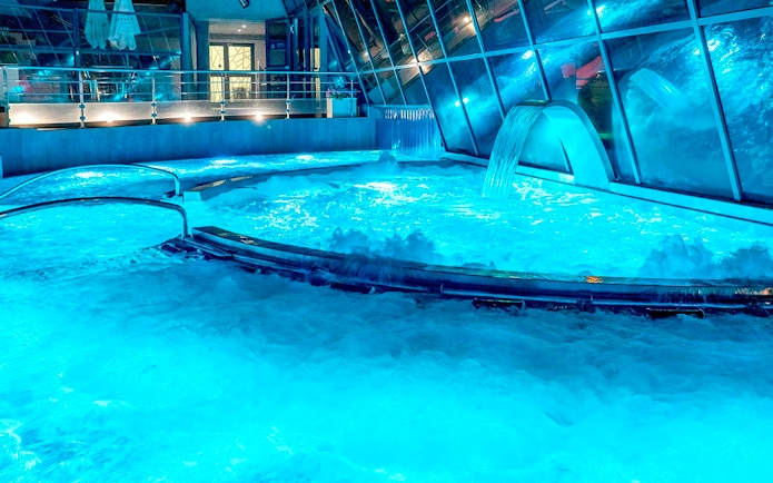 Caldea spa thermal pools with cascading water and mountain views in Andorra.