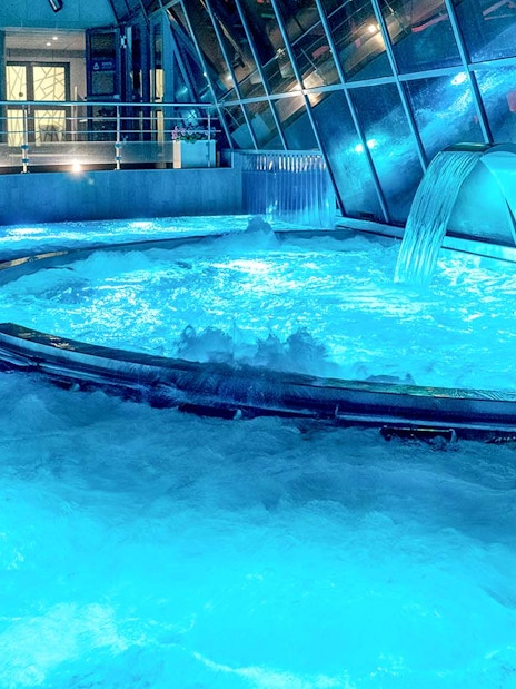 Caldea spa thermal pools with cascading water and mountain views in Andorra.
