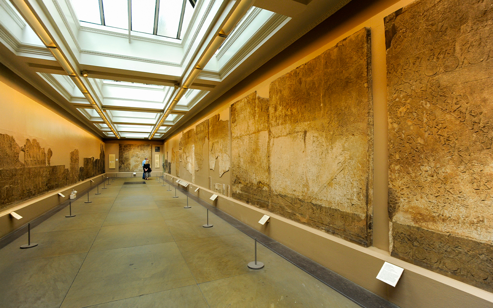 British Museum exhibition room with ancient wall carvings displayed.