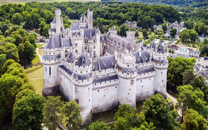 Castle of Pierrefonds surrounded by lush greenery, Oise, France.