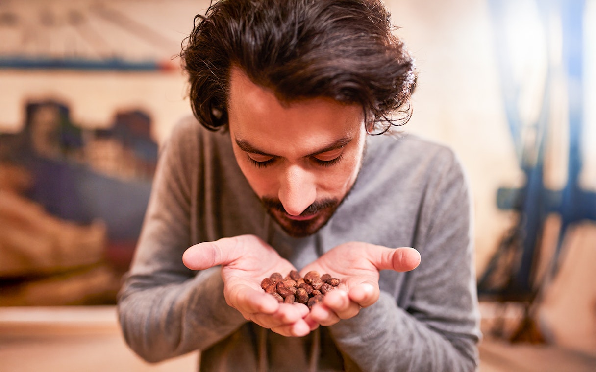 Guest smelling cocoa beans at Chocoversum, Hamburg.