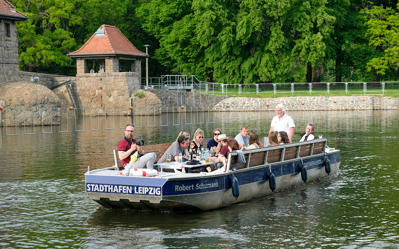 Motorboat tour on Karl Heine Canal, Leipzig with guests exploring the scenic waterway.