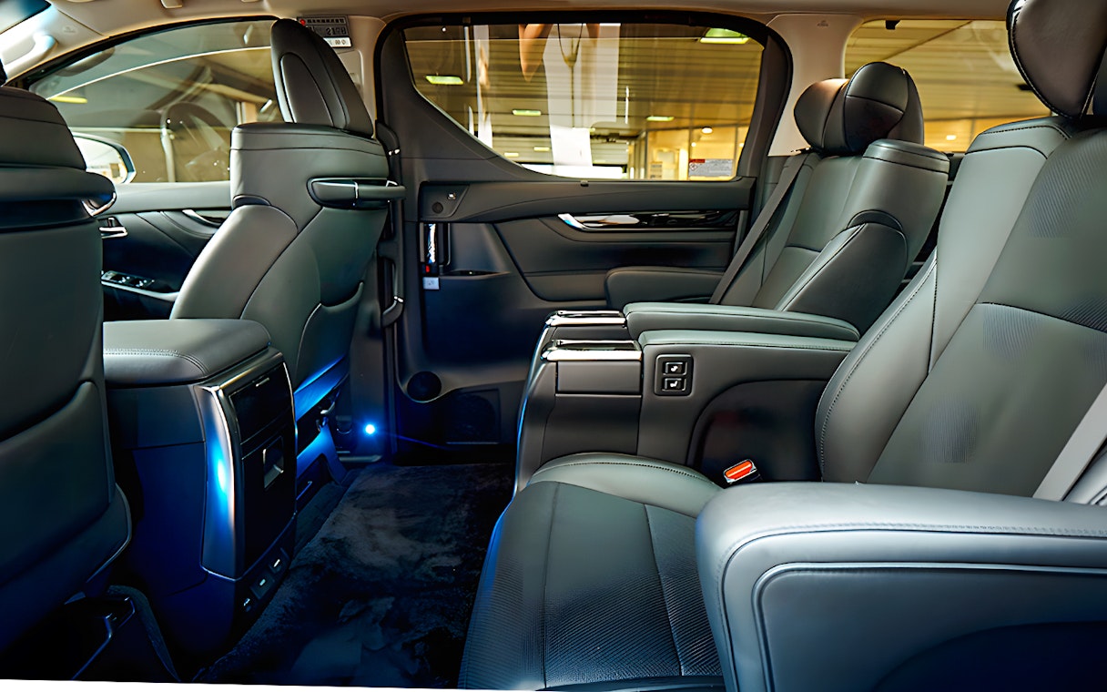 Luxury car interior for airport private transfer with leather seats and ambient lighting.