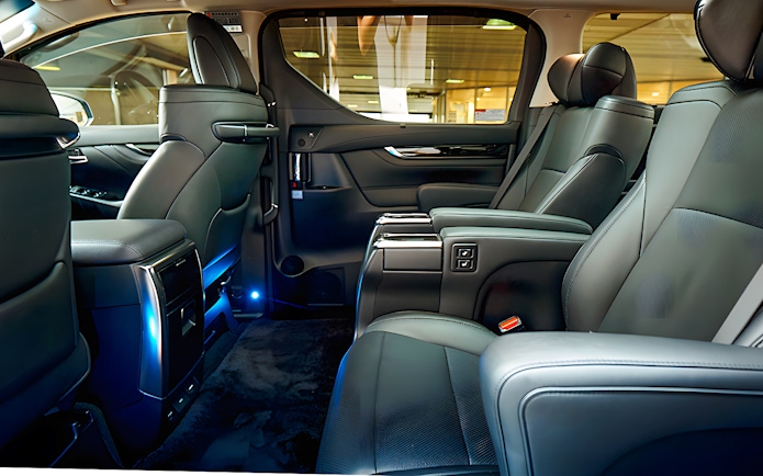 Luxury car interior for airport private transfer with leather seats and ambient lighting.