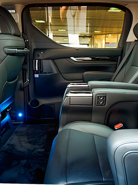 Luxury car interior for airport private transfer with leather seats and ambient lighting.