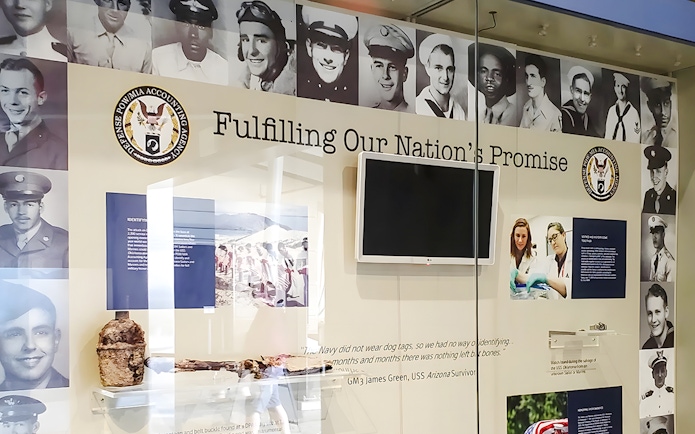 USS Arizona memorial exhibit with photos of servicemen and historical artifacts.
