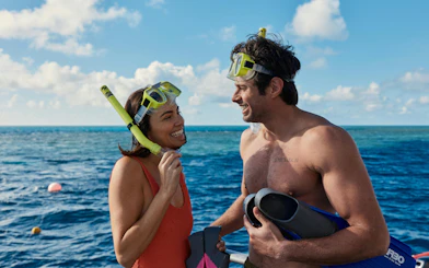 Snorkelers smiling on a boat during Whitehaven Beach tour, Whitsundays Island.