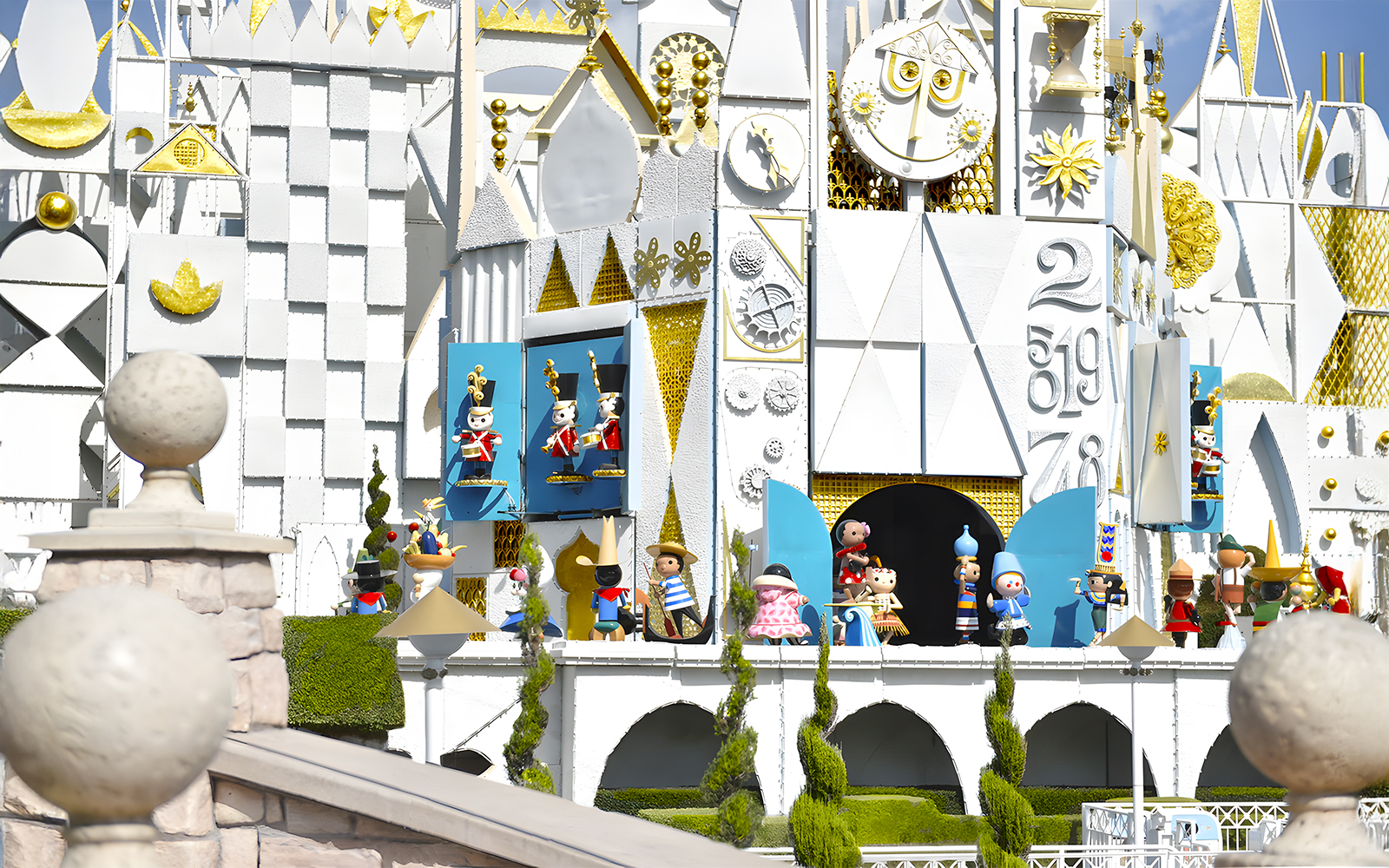 It's a Small World ride facade at Disneyland Park, California, featuring colorful figures and clock.