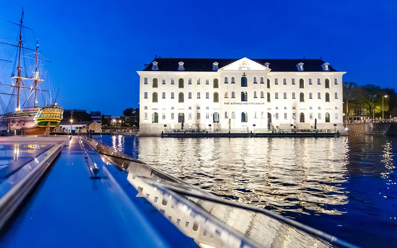 Maritime Museum illuminated at night during a winter evening cruise in Amsterdam.
