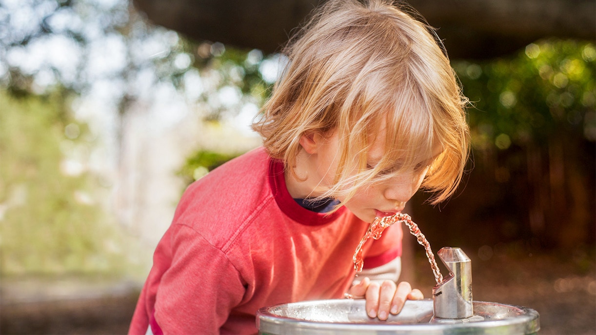 Child drinking from a water fountain in Boboli Gardens, Florence.
