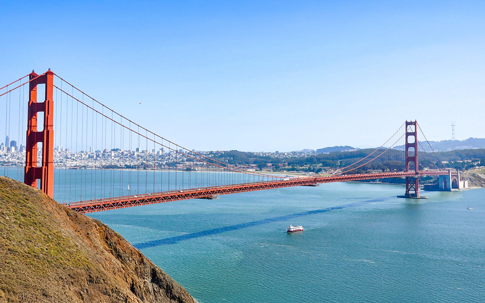 Aerial view of Golden Gate Bridge and bay cruise ship in San Francisco, USA.