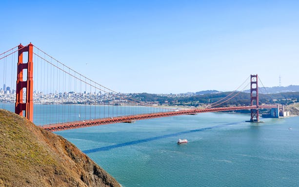 Golden Gate Bridge aerial view with bay cruise ship in San Francisco morning.