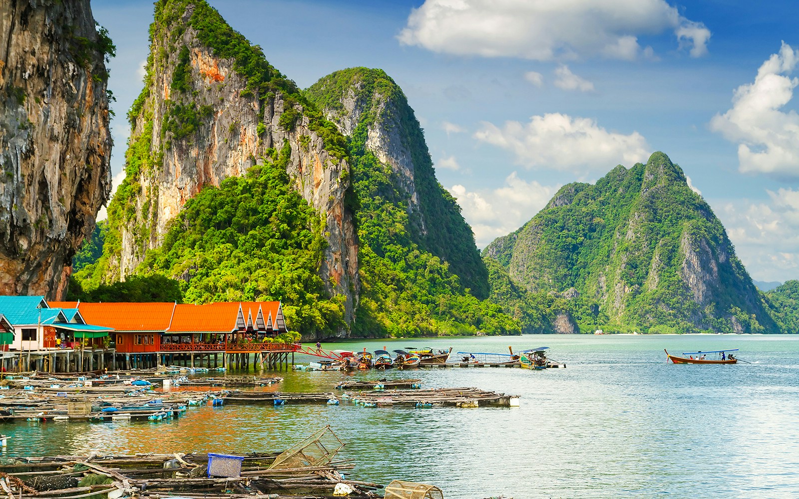 Koh Panyee stilt village with boats and limestone cliffs in Phang Nga Bay, Thailand.