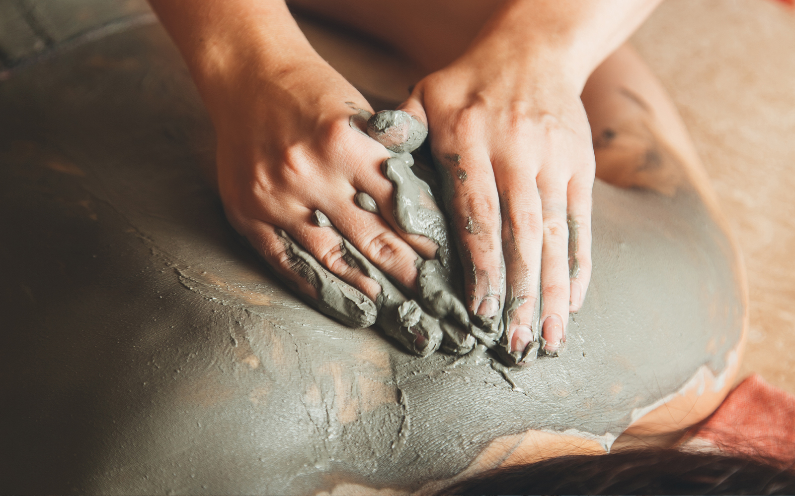 Visitors enjoying mud treatments at a spa in a serene outdoor setting.